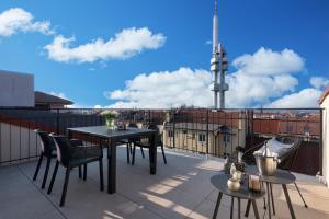 eine Terrasse mit Tischen und Stühlen auf dem Balkon in der Unterkunft Hidden Art Boutique Residence in Prag