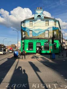 a green building with a painting on the side of it at Lovely 1 bedroom apartment in South East London in London