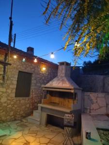 a stone fireplace in a backyard at night at Traditional House Kakopetra in Nafplio
