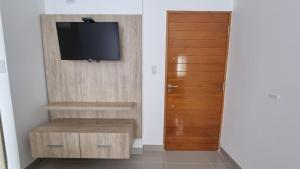 um quarto com uma televisão e uma porta de madeira em Hermoso departamento, excelente ubicación. em Salta