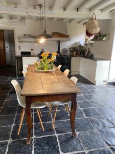 a kitchen with a wooden table with a vase of flowers on it at Domus Mater in Oudenaarde