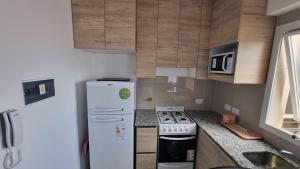 a small kitchen with a refrigerator and a stove at Hermoso departamento, excelente ubicación. in Salta