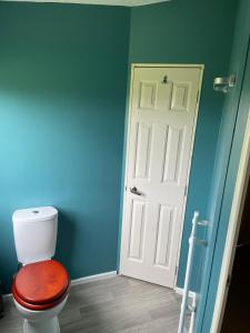 a bathroom with a toilet with a wooden seat and a door at Nutley Farm in Winfrith Newburgh