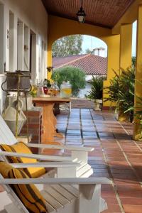 um pátio com uma mesa e cadeiras num alpendre em Quinta Da Torre - Óbidos Country House em Óbidos