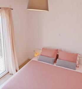 a bedroom with a large bed with pink and gray pillows at Nika in Postira +22 photos