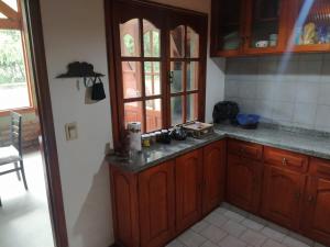 cocina con armarios de madera y encimera en Habitacion privada en cabaña compartida "Los Cordobeses" en San Martín de los Andes