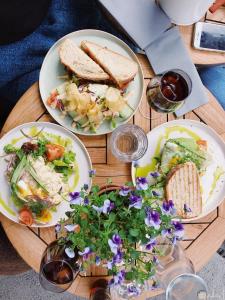 アレクサンドリアにあるشقة فندقية مكيفة ميامي ع البحر مباشرةًの木製テーブルの上に2皿の料理(サンドイッチ付)