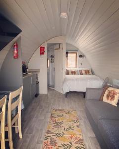 ein Wohnzimmer mit einem Bett und einem Sofa in der Unterkunft Duirinish Pods with Private Hot Tubs and Duirinish Bothy with No Hot Tub in Plockton