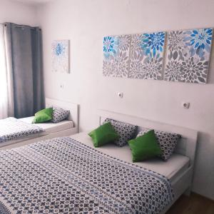 - une chambre avec 2 lits et des oreillers verts dans l'établissement Apartment Katica Mostar, à Mostar