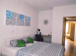 a bedroom with a bed with two green pillows at Apartment Katica Mostar in Mostar