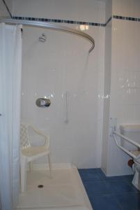 a bathroom with a shower with a chair in it at West View Accomodation in Louisburgh