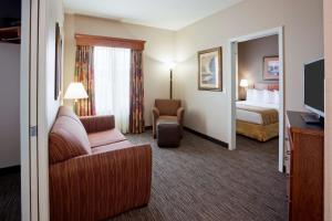 a hotel room with a couch and a bed and a television at GrandStay Residential Suites Hotel Faribault in Faribault