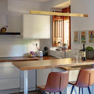 a kitchen with a wooden counter top and chairs at Apartamento Garcia Lorca II in Granada