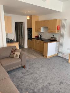 a living room with a couch and a kitchen at Delamere ground floor holiday flat in Blackpool