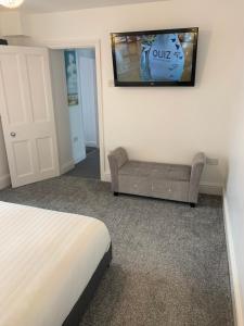 um quarto com uma cama e uma televisão na parede em Delamere ground floor holiday flat em Blackpool