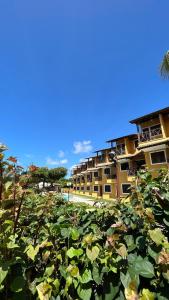 a field of plants with a building in the background at Merepe Residence in Porto De Galinhas