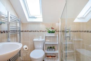 a bathroom with a toilet and a sink and a shower at The Litte Hideaway in Saint Columb Minor +12 photos