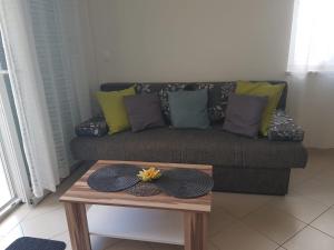 ein Sofa mit Kissen und einem Couchtisch im Wohnzimmer in der Unterkunft Apartments Hausmann in Novalja