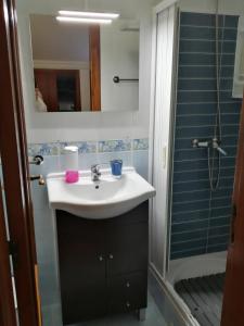 uma casa de banho com um lavatório e um chuveiro em Ocean Studio em Peniche