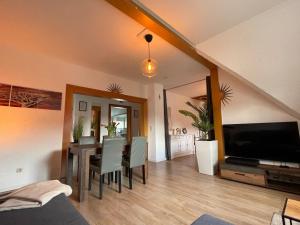 a living room with a dining room table and a television at Suite Dilara by NINJA SPACES - 105QM Maisonette, Garten, Parkplatz in Arnsberg