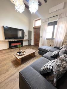 a living room with two couches and a flat screen tv at BÁNOVA APARTAMENTO TURÍSTICO in Alhama de Aragón