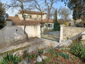 a house with a gate and a fence at La chênaie in Saint-Restitut