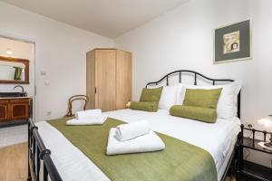 a bedroom with a large bed with two towels at Bonihome Apartments in Punat +56 photos