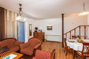 a living room with a table and chairs and a dining room at Bonihome Apartments in Punat