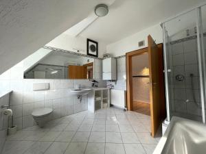 a bathroom with a toilet and a sink and a shower at Suite Dilara by NINJA SPACES - 105QM Maisonette, Garten, Parkplatz in Arnsberg +18 photos