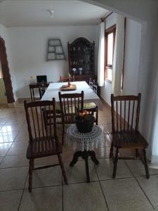 a dining room with a table and chairs with a bowl on a table at Recanto do Sossego in Campos do Jordão