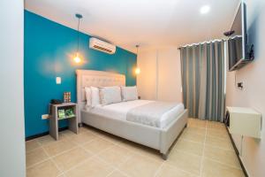 a bedroom with a bed and a blue wall at Greenview Medellin By St Hoteles in Medellín +72 photos