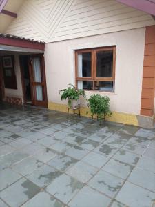 a house with two plants sitting on a patio at Recanto do Sossego in Campos do Jordão