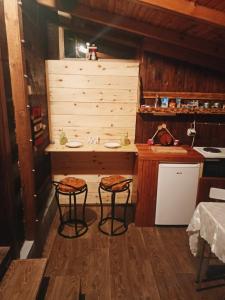 een keuken met 2 krukken en een wastafel in een kamer bij Brvnara Ljubičica in Kremna