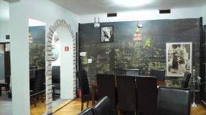 DUKAT في Horyniec: غرفة طعام مع كراسي سوداء وجدار مع مدينة