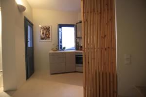 a kitchen with a wooden wall in a room at Villa Nefeli Tinos in Triandáros +18 photos
