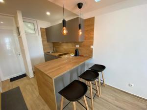 une cuisine avec deux tabourets de bar et un comptoir dans l'établissement Studio apartment F&J, à Sveti Filip i Jakov