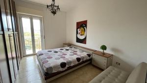 a bedroom with a bed and a couch and a window at A'mare in Siculiana Marina