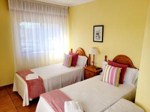 a hotel room with two beds and a window at Vilariño Moscoso in Arzúa