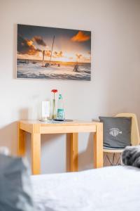 a table in a room with a picture on the wall at Pension Mai-Scholle in Borkum