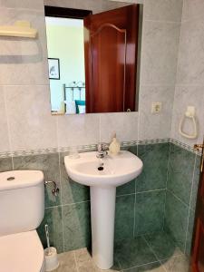 y baño con lavabo, aseo y espejo. en Vilariño Moscoso, en Arzúa