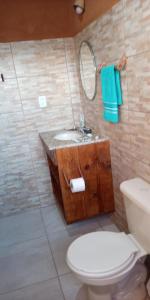 a bathroom with a sink and a toilet and a mirror at Chalés Portal Verde - Seja bem vindo in Carrancas +38 photos