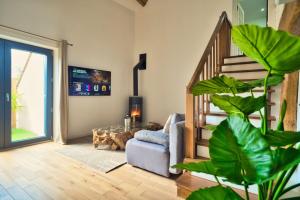 sala de estar con escalera y sofá en L’Oxalis villa, Sauna et Jaccuzi privatif en Bullion