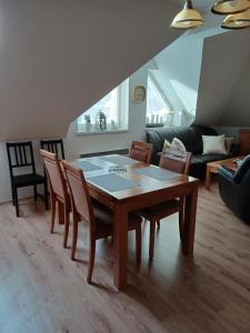 ein Wohnzimmer mit einem Holztisch und Stühlen in der Unterkunft Apartmán s garážou Donovaly centrum in Donovaly