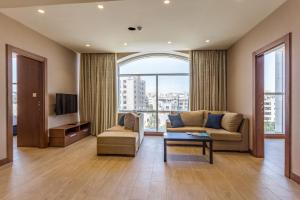 a living room with a couch and a tv at The Seventh Star Hotel Suites in Amman