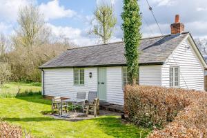 a white house with a table and chairs in the yard at Little Melrose in Yalding