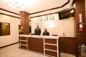 two men standing at a counter in a lobby at The Caye Hotel in Caye Caulker