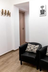 - un salon avec un canapé noir et une chaise dans l'établissement Sannio Deluxe Apartment - San Giovanni, à Rome
