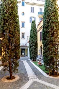 une rangée d'arbres devant un bâtiment dans l'établissement Sannio Deluxe Apartment - San Giovanni, à Rome