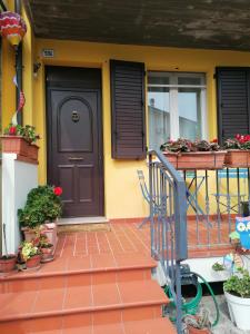 a house with a black door and some potted plants at La birichina in Santarcangelo di Romagna