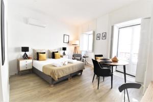 科英布拉Sophia Studios的一间卧室，里面有一张床、一张桌子和几把椅子。